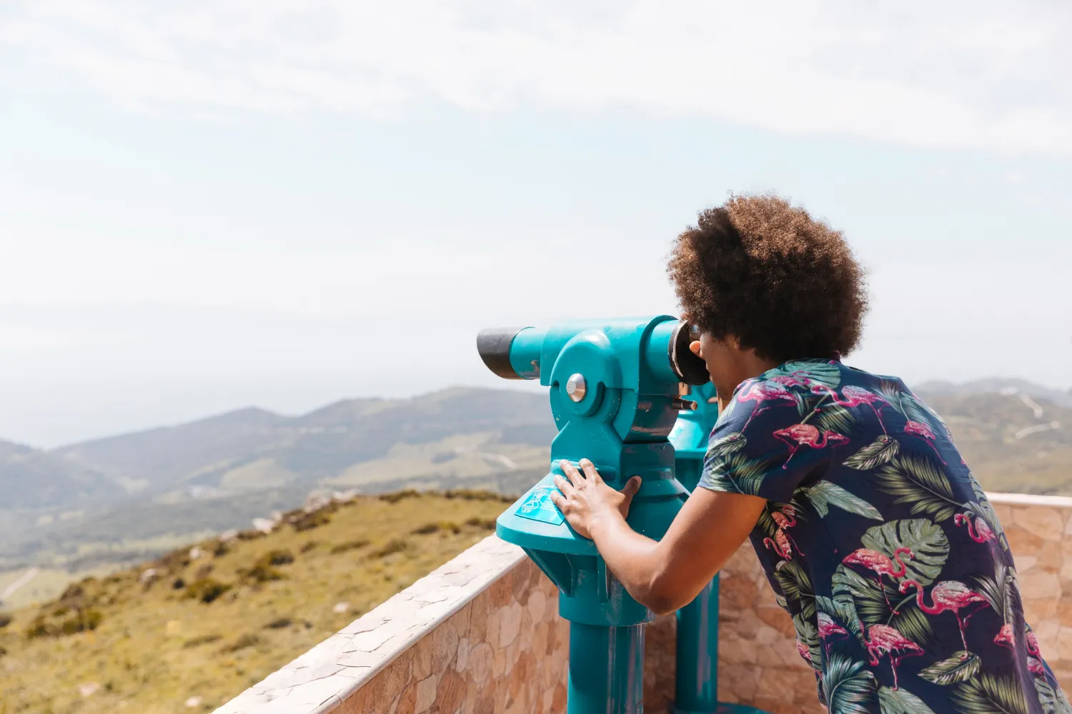 Visitor looking through binoculars at Lake Malawi, taking in the scenery